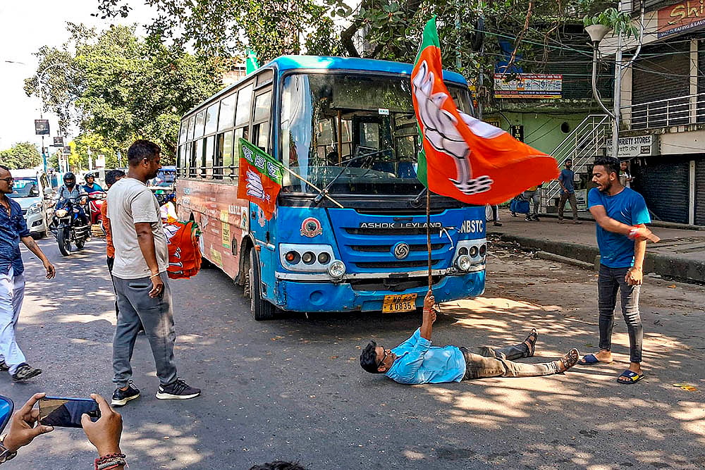| Photo: PTI : BJP's Bengal Bandh: A BJP worker block the way of a state government bus during the party's 12-hour general strike in Siliguri 